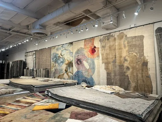 Wall of large hand-knotted rugs on display in the Organic Looms Scottsdale showroom