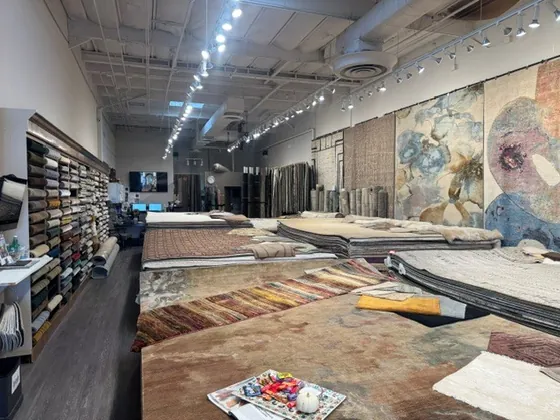 Organic Looms rug showroom floor in the Scottsdale Design District, with hand-knotted rugs stacked and laid out