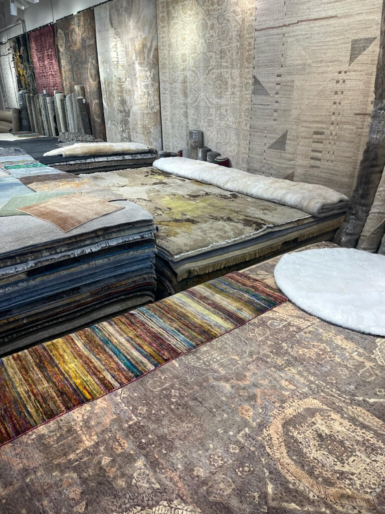 Stacks of hand-knotted rugs on the Organic Looms showroom floor in Scottsdale